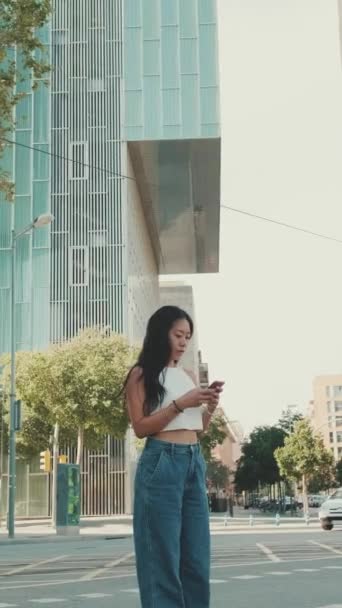 年轻女性站在现代城市背景下 在手机上使用地图应用程序 — 图库视频影像