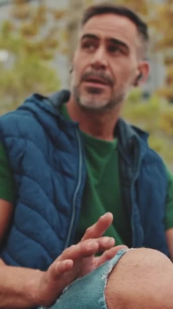 Чоловік Середнього Віку Відпочиває Слухає Музику Сидячи Лавці Парку — стокове відео
