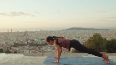 Kız şafak vakti gözetleme noktasında amuda kalkıp yoga yapıyor.