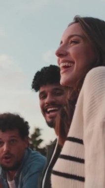 Gençler güzel manzaraya bakar ve balkonda dikilirken konuşurlar.