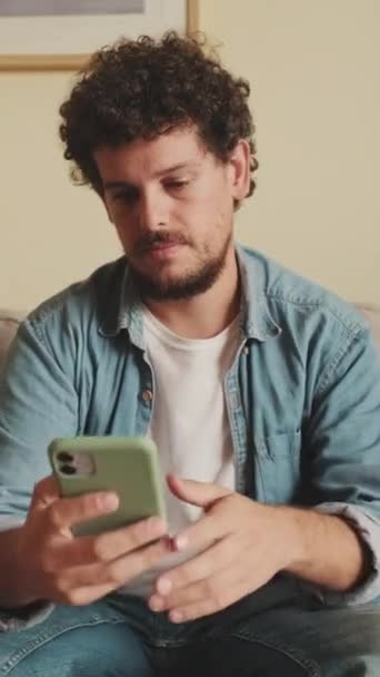 Homem Perturbado Sentado Sofá Usando Telefone Celular — Vídeo de Stock