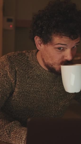 Young Man Sits Apartment Drinks Coffee Mug Uses Laptop — Stock Video