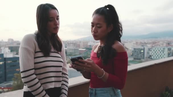 Дівчата Спілкуються Використовуючи Мобільний Телефон Стоячи Балконі Сучасному Місці Фоні — стокове відео