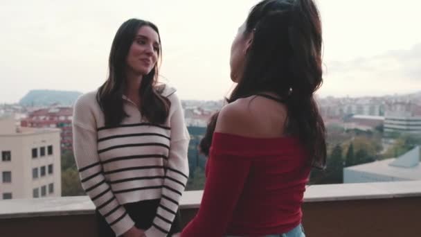Dwie Dziewczyny Przyjaciele Rozmawiają Stojąc Balkonie Nowoczesnym Mieście Tle — Wideo stockowe