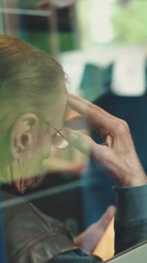 Dikey video, düşünceli yaşlı adamın yakınlaşması tren coupe 'si, camdan görüş.