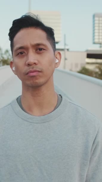 Junger Mann Mit Drahtlosen Kopfhörern Steht Auf Einer Brücke Dreht — Stockvideo