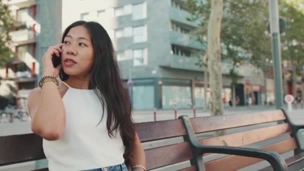 Ung Kvinde Sidder Bænken Taler Mobiltelefon – Stock-video