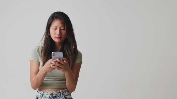 Wanita Muda Yang Menggunakan Ponsel Terisolasi Atas Latar Belakang Putih — Stok Video