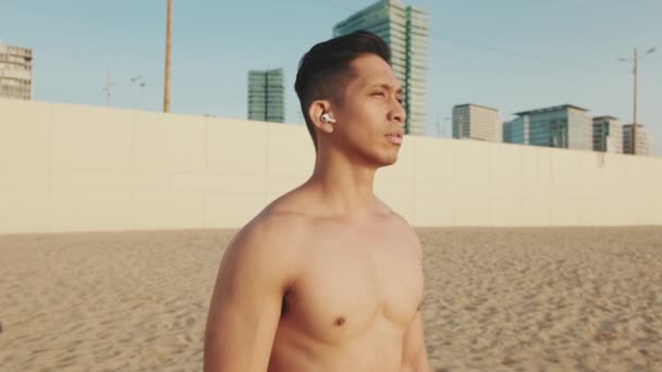 Hombre Atlético Joven Pie Playa Con Auriculares — Vídeos de Stock