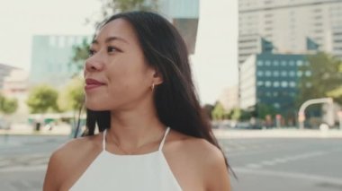 Modern şehir geçmişine bakan güzel genç bir kadının yakın çekimi.