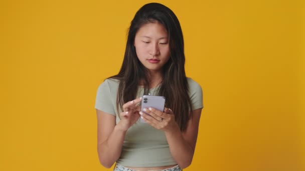 Junge Frau Schaut Aufs Handy Und Sucht Sich Etwas Aus — Stockvideo