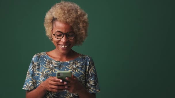 Mutlu Kadının Elinde Cep Telefonu Var Mavi Arka Planda Izole — Stok video