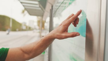 Tanımlanamayan bir adamın eli toplu taşıma trafiğini işaret ediyor.