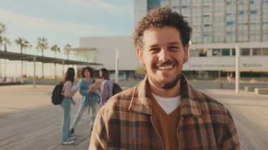 Genç adam kameraya bakıyor.