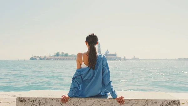 Девочка Длинными Каштановыми Волосами Одетая Голубую Рубашку Сидит Смотрит Море — стоковое фото