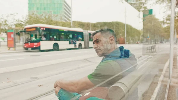 평상복을 남자는 시내의 시설에서 트램을 기다리는 전화를 — 스톡 사진