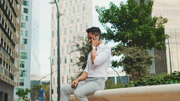 Jovem Empresário Conversando Celular Enquanto Senta Lado Centro Negócios — Fotografia de Stock