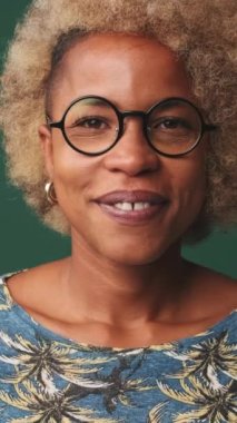 Yakından, genç bir kadının yüzünün yarısı mavi arka planda izole bir şekilde gülümseyerek kameraya bakıyor.