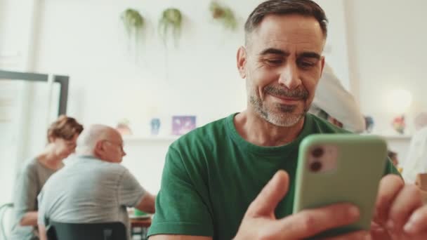 Orta Yaşlı Bir Adam Kafede Oturup Cep Telefonundan Video Izliyor — Stok video