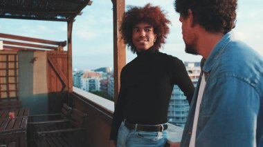 Çeşitli gençler terasta birlikte vakit geçirir, yakın arkadaşlar konuşur ve tanıştıklarında karşılıklı haberleşirler, pozitif yoldaşlar birlikte sosyalleşmeyi severler.