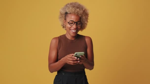 Laughing Woman Chatting Mobile Phone Orange Background — стоковое видео