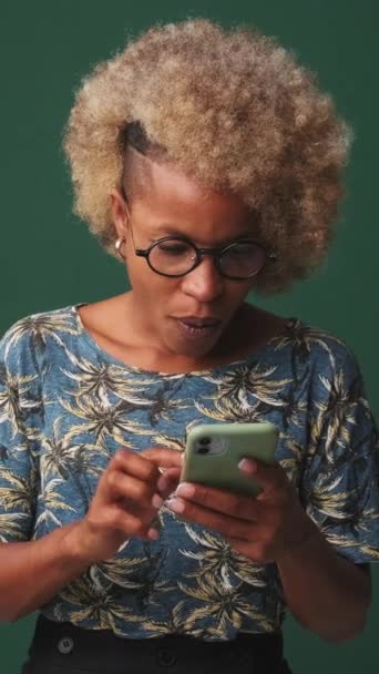 Mladá Žena Překvapen Držení Telefonu Rukou Izolované Modrém Pozadí — Stock video