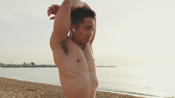 Young Athletic Man Standing Beach Stretching His Arm Muscles Training — Video Stock