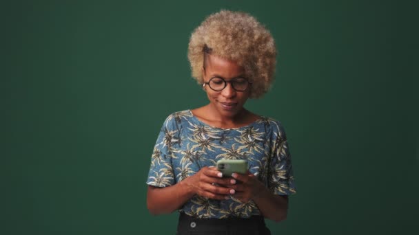 用蓝色背景隔离的手机微笑的女人 — 图库视频影像