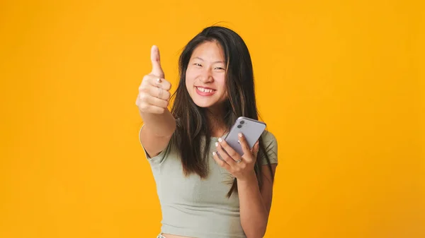 Lächelndes Mädchen Grauem Top Scrollt Auf Dem Bildschirm Des Smartphones — Stockfoto