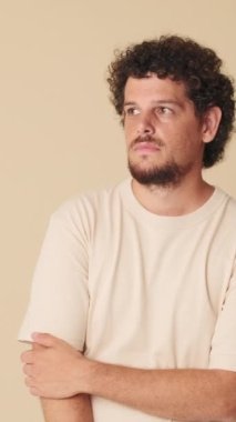 Genç adam sorunu hakkında düşünüyor, bej arka planda izole edilmiş bir şeyi hatırlıyor.