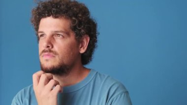 Yakından bakınca, genç adam sorununu düşünüyor, mavi arka planda izole edilmiş bir şeyi hatırlıyor.