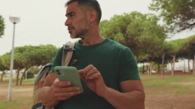 Akıllı telefonda harita uygulaması kullanan orta yaşlı bir adam