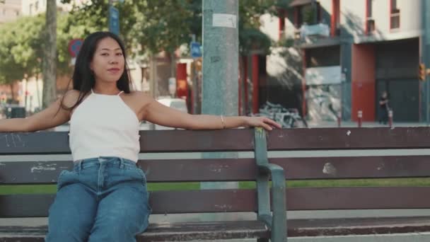 Giovane Donna Seduta Sulla Panchina Sfondo Paesaggio Urbano — Video Stock