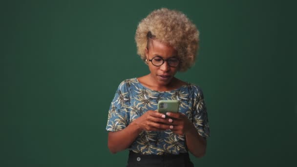 Mutlu Kadın Zaferi Kutluyor Elinde Telefon Mavi Arka Planda Soyutlanmış — Stok video