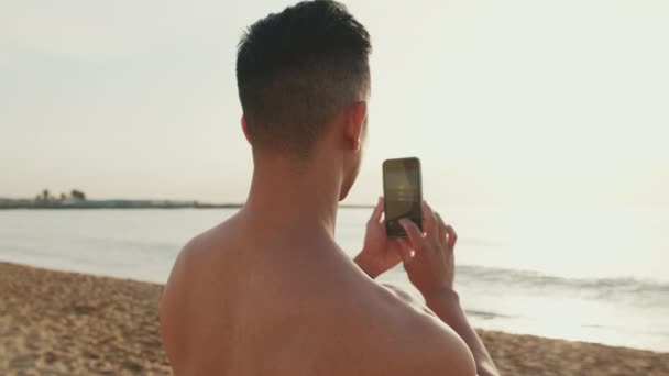 Zbliżenie Młody Sportowiec Stojący Plaży Kręcący Wideo Przez Telefon Komórkowy — Wideo stockowe