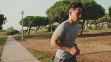 Young man running along the path in the park