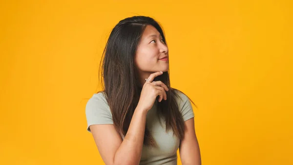 女の子でグレートップ見ますカメラ 笑顔とイチャイチャ絶縁上の黄色の背景にスタジオ — ストック写真