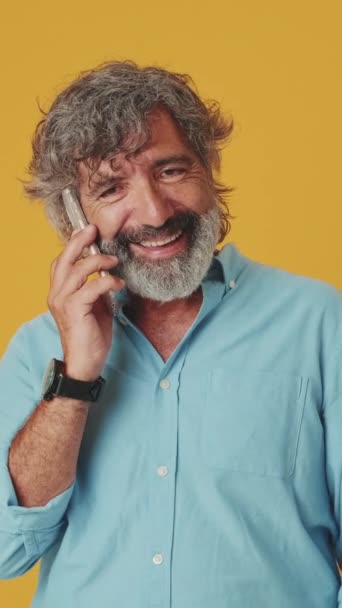 Šťastný Starší Šedovlasý Muž Mluví Mobilním Telefonu Izolované Oranžovém Pozadí — Stock video