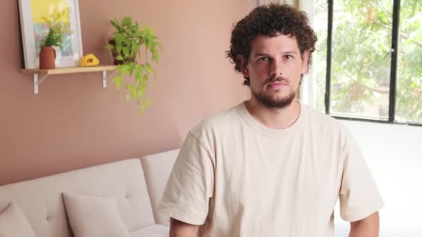 Guy Steht Gemütlichen Wohnzimmer Verschränkt Die Arme Und Blickt Lächelnd — Stockvideo