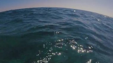 Ufuk çizgisi kıvrımlı, alçak açılı, deniz manzaralı su yüzeyi. Deniz yüzeyindeki küçük dalgalar
