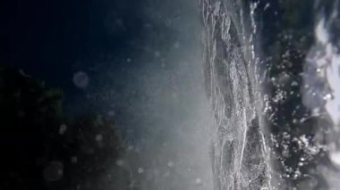 Akdeniz 'in parlak güneş ışınlarında deniz dalgaları ve kıyı kayalıklarıyla sualtı denizi.