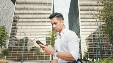 Genç işadamı dışarıdan cep telefonu kullanıyor.