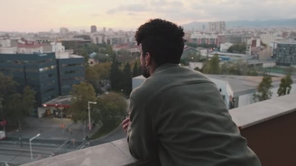 Nærbildet Ung Mann Står Balkongen Ser Byen – stockvideo
