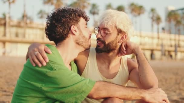 Pareja Homosexual Abrazándose Besándose Mientras Está Sentada Playa — Vídeos de Stock
