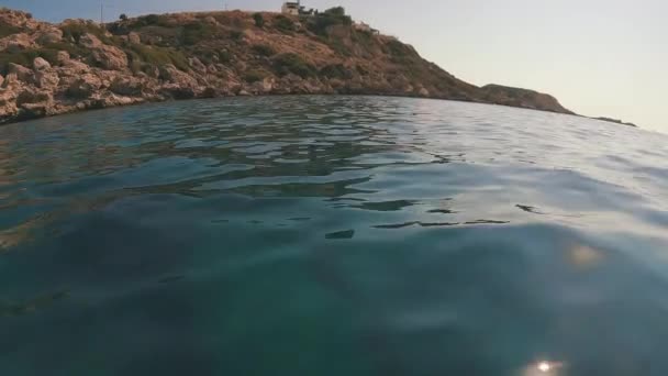 カメラは 岩の海岸に水の上に低く移動する — ストック動画