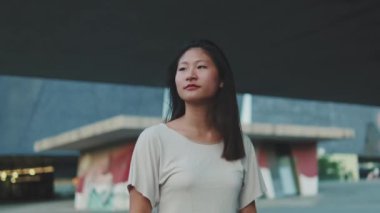 Şehirde yürüyen neşeli genç bir kadın.