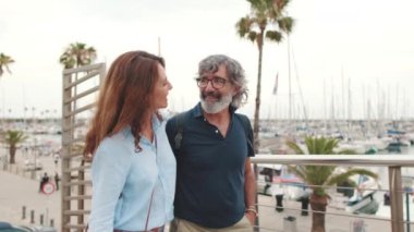 Orta yaşlı çift yürüyor, birbirlerine sarılıyorlar, yatta konuşuyorlar.