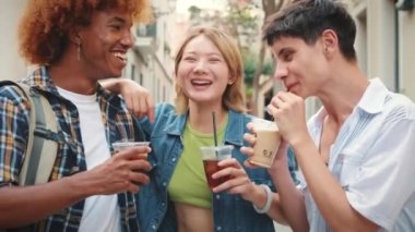 Kapatın, şirket arkadaşları ellerinde içkilerle şehir caddesinde yürüyor, sohbet ediyor ve gülüyorlar.