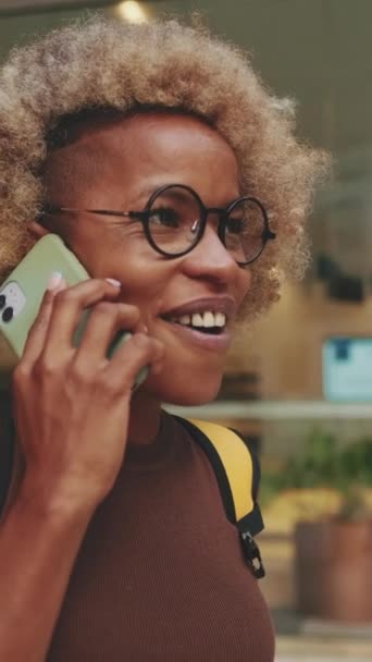 Usmívající Žena Batohem Ramenou Mluví Mobilním Telefonu Zatímco Stojí Ulici — Stock video