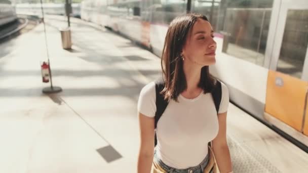 Genç Bir Kadın Elinde Cep Telefonuyla Tren Istasyonunun Platformu Boyunca — Stok video